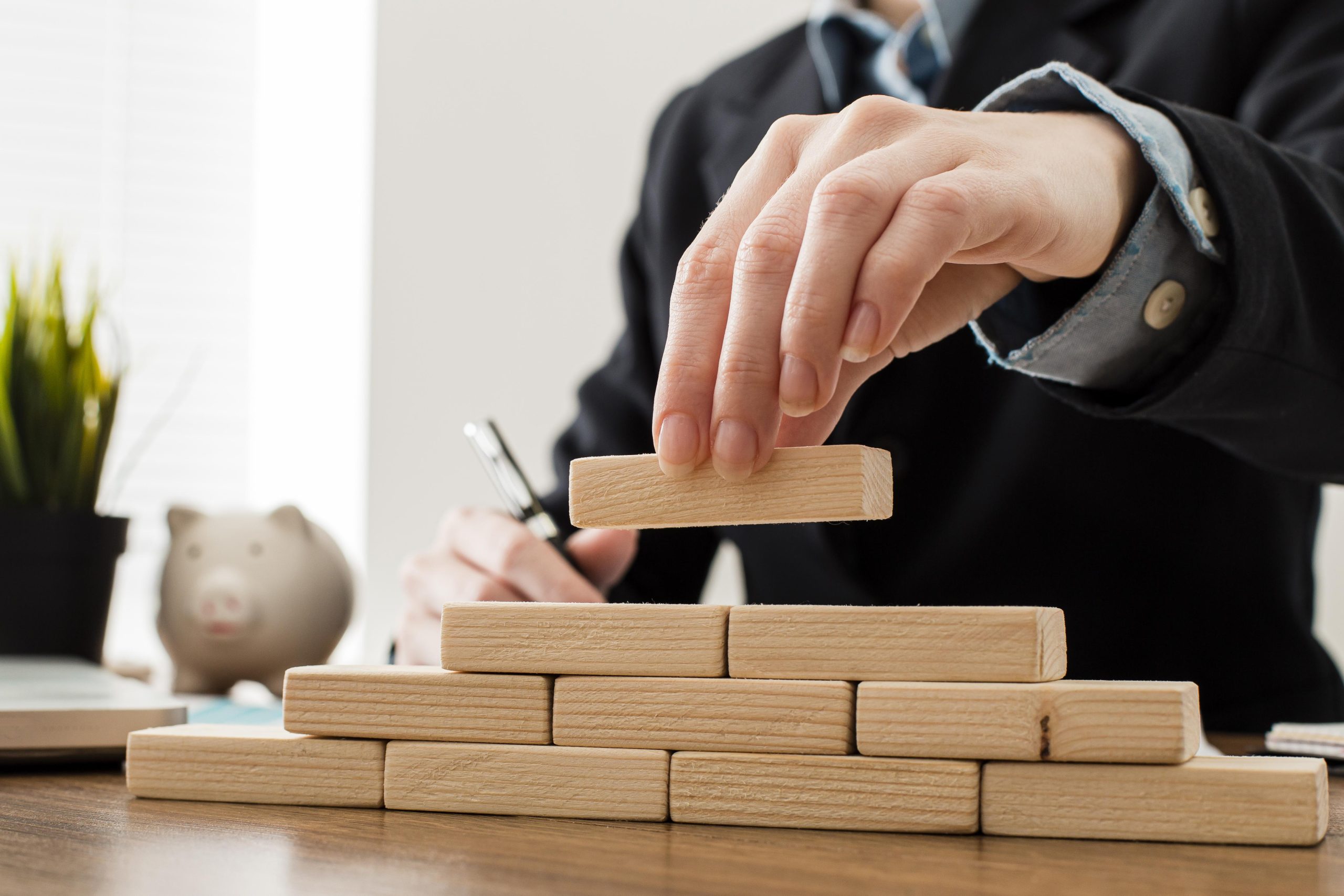 front-view-businessman-with-wooden-building-blocks